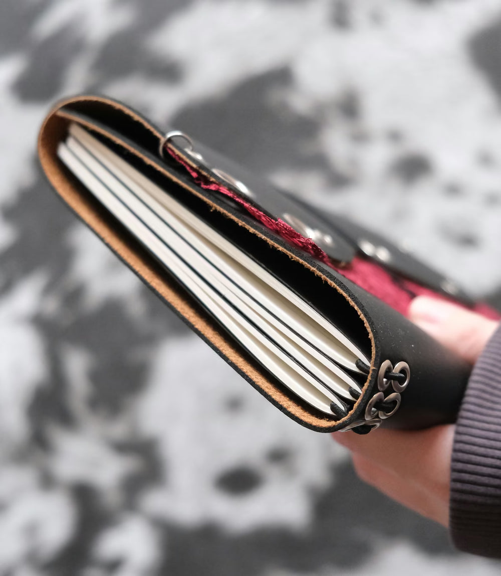 Carnet Lisse vague dentelle rouge A5 tenu en main, vue de la tranche et des pages