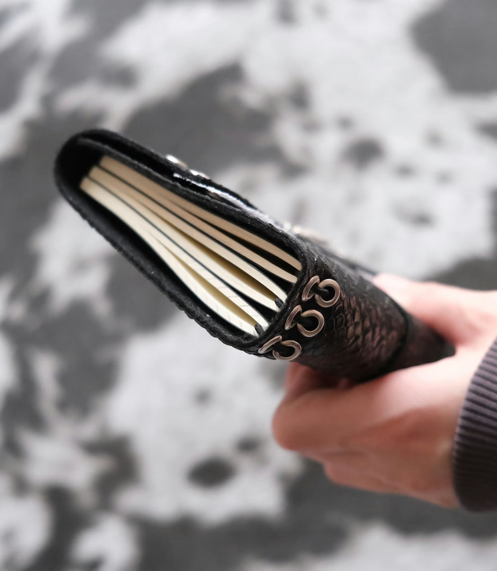 Carnet Python dentelle blanche A6 tenu en main, vue de la tranche et des pages